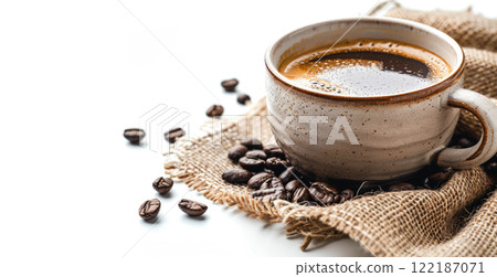 Close-up of cup with hot tasty coffee on burlap surrounded by brown coffee beans isolated on white 122187071