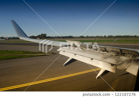 Aircraft Wing with Extended Spoilers A Close Up View on the Runway Aircraft Wing with Extended Spoilers A Close Up View on the Runway 122187276