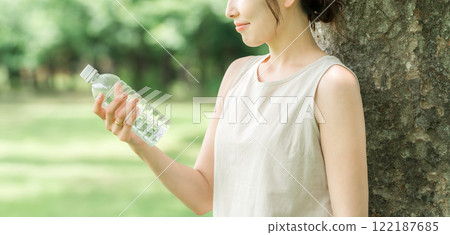 Relaxed woman drinking bottled water, mineral water, and hot water 122187685