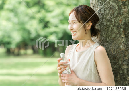 Relaxed woman drinking bottled water, mineral water, and hot water Relaxed woman drinking bottled water, mineral water, and hot water 122187686