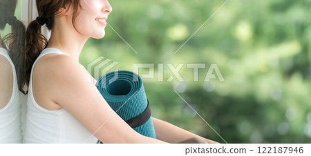 一個帶著瑜珈墊的瑜珈教練的女人，一個做瑜珈和普拉提的女人 122187946