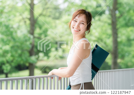 一個帶著瑜珈墊的瑜珈教練的女人，一個做瑜珈和普拉提的女人 122187947