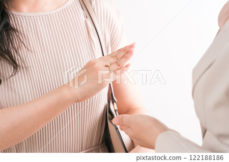 A woman choosing a wedding ring and a salesperson/staff at a jewelry store, accessory store, jewelry shop, or department store 122188186