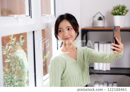 Portrait young asian business woman using smart phone for video call by the window in living room. 122188461