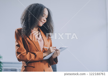 Beautiful young Asian businesswoman smiling holding a coffee mug and laptop working at the office. Beautiful young Asian businesswoman smiling holding a coffee mug and laptop working at the office. 122188761
