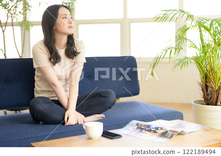 一個女人坐在沙發上和放鬆 一個女人坐在沙發上和放鬆 122189494