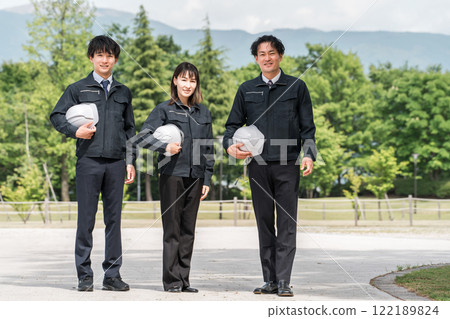 Male and female workers in landscaping and civil engineering work clothes standing in a park 122189824