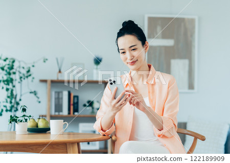 Young woman using a smartphone at home Young woman using a smartphone at home 122189909