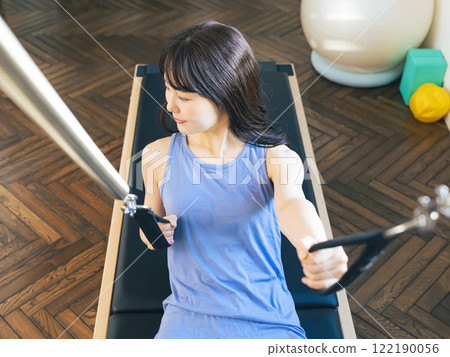 Woman doing machine pilates training 122190056