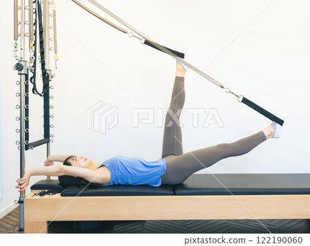 Woman doing machine pilates training 122190060