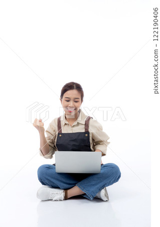 Portrait young asian business woman wearing apron holding laptop computer isolated. Portrait young asian business woman wearing apron holding laptop computer isolated. 122190406
