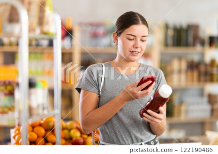 Young woman scanning qr code for ketchup 122190486