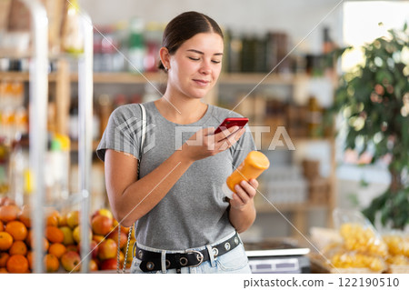 Woman scanning a package of sauce 122190510