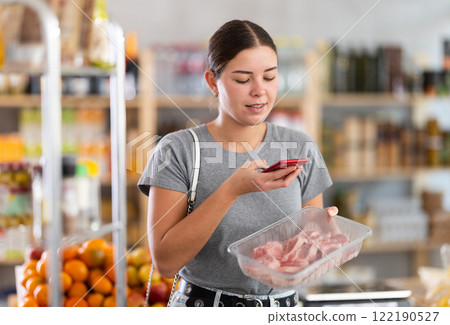 Woman scanning qr code of meat packaging Woman scanning qr code of meat packaging 122190527