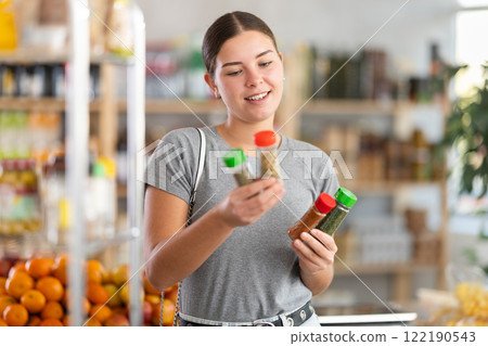 Young woman choosing spices in grocery store Young woman choosing spices in grocery store 122190543