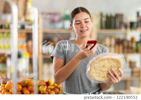 Young woman scanning qr code for four cheese pizza Young woman scanning qr code for four cheese pizza 122190552