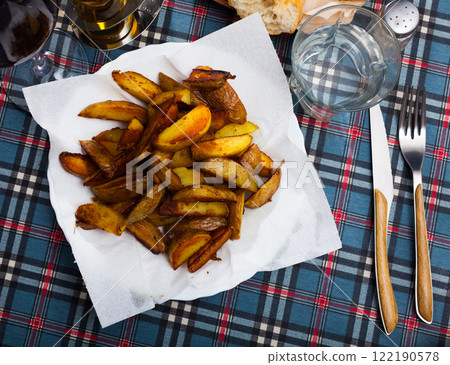 Baked in oven yellow potatoes served at plate on table Baked in oven yellow potatoes served at plate on table 122190578