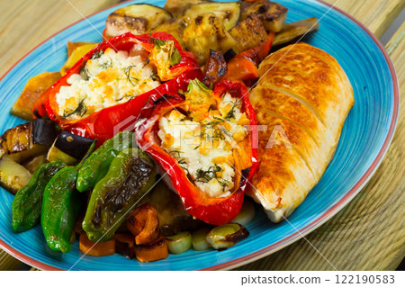 Different baked vegetables at plate with stuffed peppers and chicken fillet Different baked vegetables at plate with stuffed peppers and chicken fillet 122190583