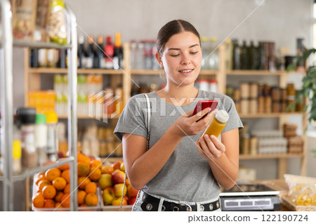 In shop youth girl scan QR code and take reading smoothie package bottle using phone camera 122190724