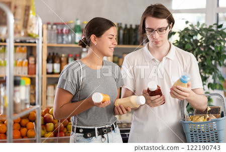 European youth girl and guy choose and buy sauce in store 122190743