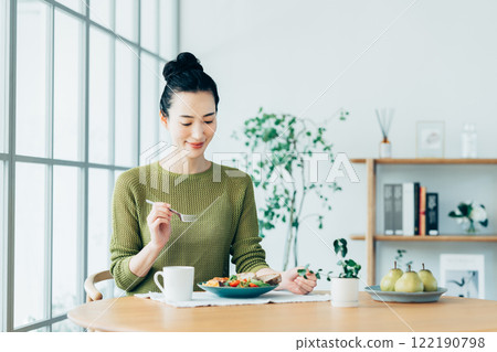 Young woman eating breakfast at home 122190798