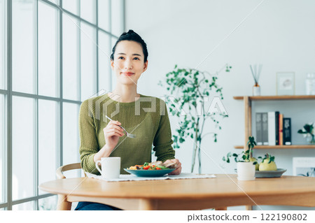 Young woman eating breakfast at home Young woman eating breakfast at home 122190802
