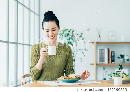Young woman eating breakfast at home 122190813