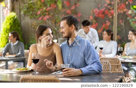 Portrait of loving couple with glasses of wine at table in an open-air restaurant 122190829