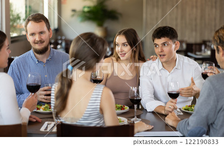 Group of friends talking and eating in restaurant Group of friends talking and eating in restaurant 122190833