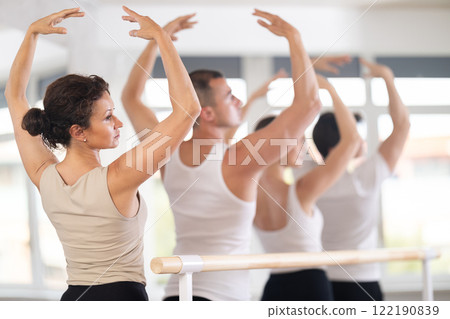 Group of dancers stand in fifth position at barre Group of dancers stand in fifth position at barre 122190839