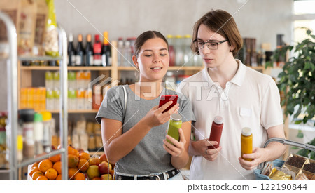 Couple young man and woman chooses smoothies Couple young man and woman chooses smoothies 122190844