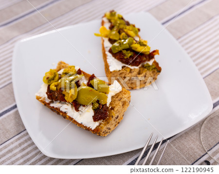 Bruschetta with sun-dried tomatoes, olives and cheese 122190945
