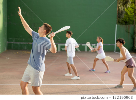 Concentrated young man paleta fronton player hitting ball with racket 122190968