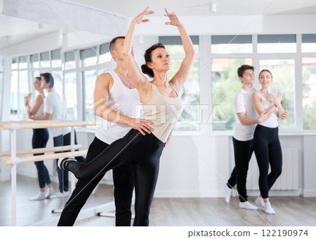 Graceful couple of ballet dancers performing supports at group class 122190974