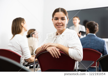 Young smiling woman attending lecture in university 122191054
