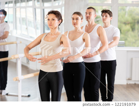 Group of dancers stand in first position at barre Group of dancers stand in first position at barre 122191079