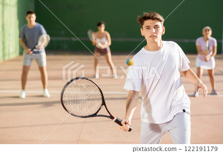 Argentinian guy playing frontenis at open-air fronton court in summer Argentinian guy playing frontenis at open-air fronton court in summer 122191179