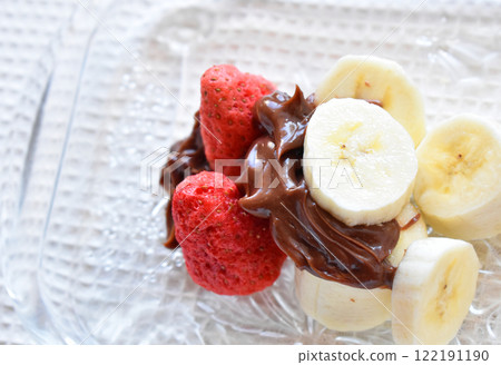 Delicious chocolate fondue with bananas and dried strawberries, made with chocolate rich in cocoa polyphenols Delicious chocolate fondue with bananas and dried strawberries, made with chocolate rich in cocoa polyphenols 122191190