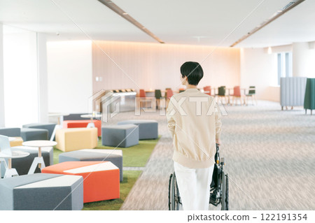 Rear view of a woman pushing a wheelchair 122191354