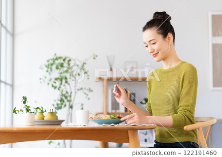 A young woman eating breakfast A young woman eating breakfast 122191460