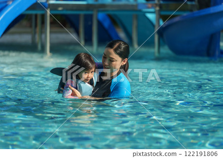 toddler baby girl in life jacket playing water splashing in swimming pool 122191806