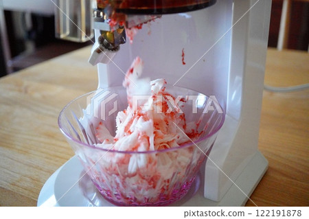 Frozen strawberry shaved ice made by shaving delicious frozen strawberries using a shaved ice machine. 122191878