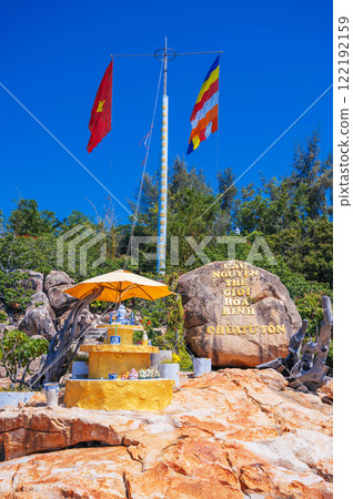 Flagpole with the flag of Vietnam on the island with the Tu ton pagoda on the background of the sea on a clear day Flagpole with the flag of Vietnam on the island with the Tu ton pagoda on the background of the sea on a clear day 122192159
