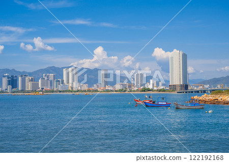 View from the sea of fishing boats and the Vietnamese city of Nha Trang on a sunny cloudy day 122192168