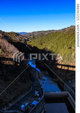 A mild autumn evening at Nara's Nunome Dam in the depths of winter - the dam casts a large shadow over the surface of the Nunome River 122192660