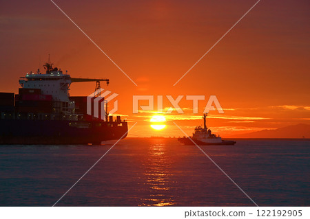 傍晚時分，在夕陽的背景下，貨船進入港口 122192905