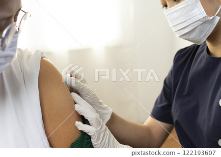 Elderly Asian woman getting coronavirus vaccine by nurse. Medical worker prepare syringe. Elderly Asian woman getting coronavirus vaccine by nurse. Medical worker prepare syringe. 122193607