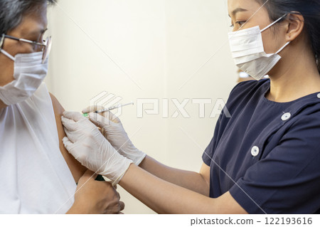 Elderly Asian woman getting coronavirus vaccine by nurse. Medical worker prepare syringe. Elderly Asian woman getting coronavirus vaccine by nurse. Medical worker prepare syringe. 122193616