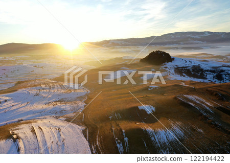 Flying over snowy winter hills in sunset lights Flying over snowy winter hills in sunset lights 122194422