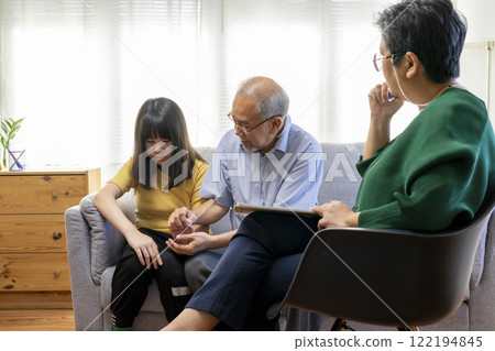 Parents telling the psychologist about family or child problems. Depressed girl and her parent or grandpa having session with psychiatrist in clinic. Parents telling the psychologist about family or child problems. Depressed girl and her parent or grandpa having session with psychiatrist in clinic. 122194845